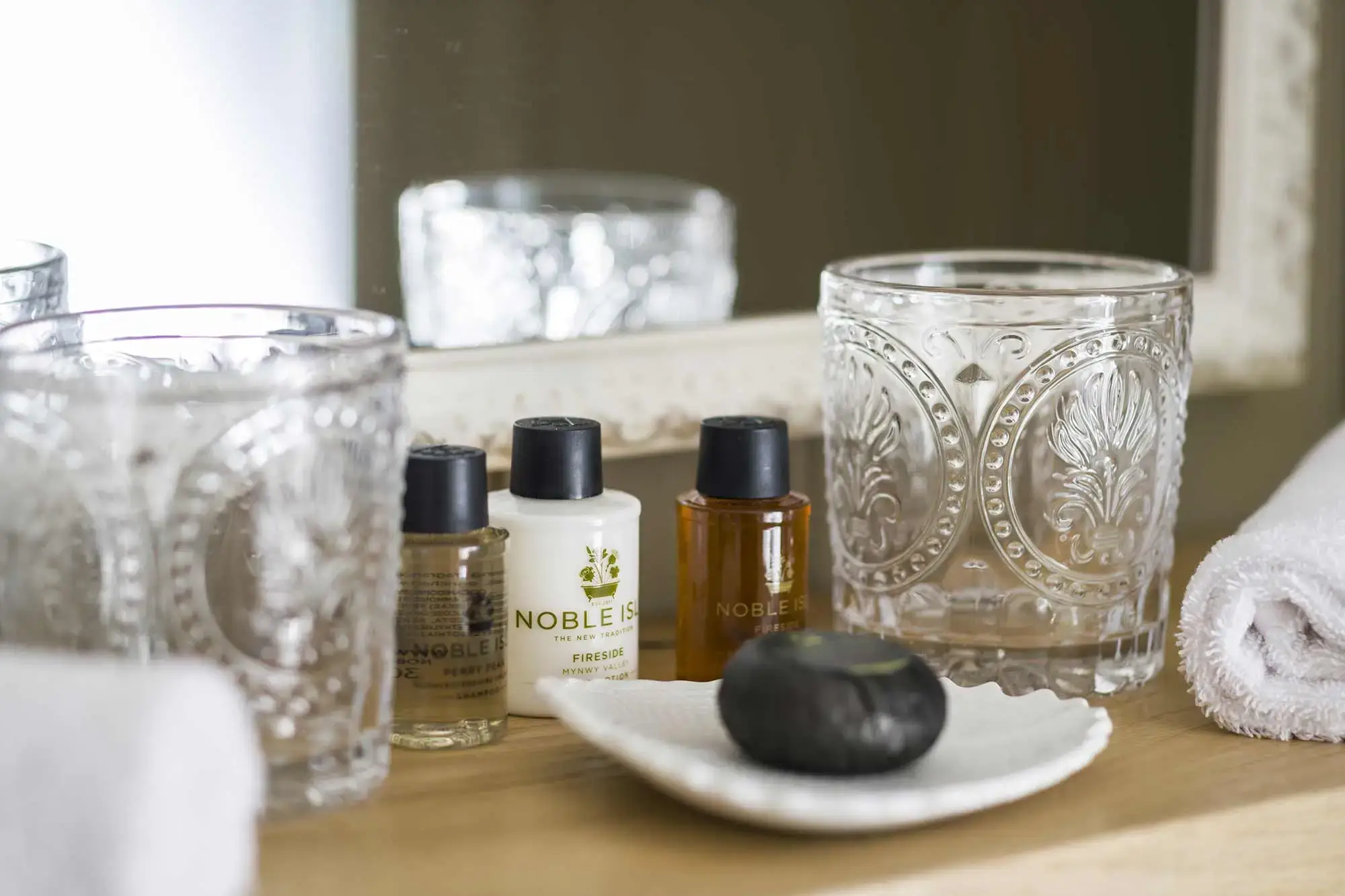 Two glasses and three bottles on a table