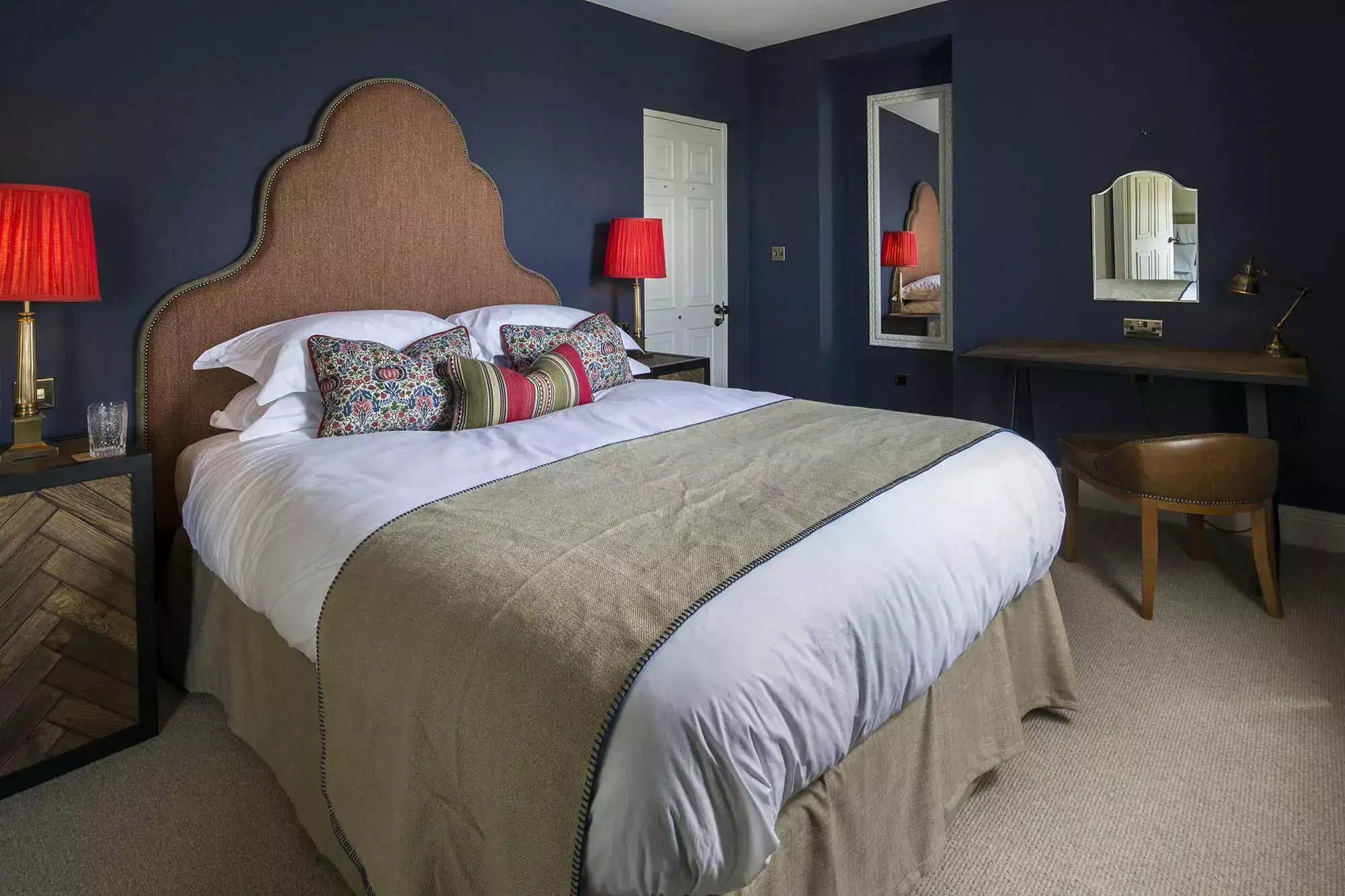 Bed with red lamps and a brown leather chair