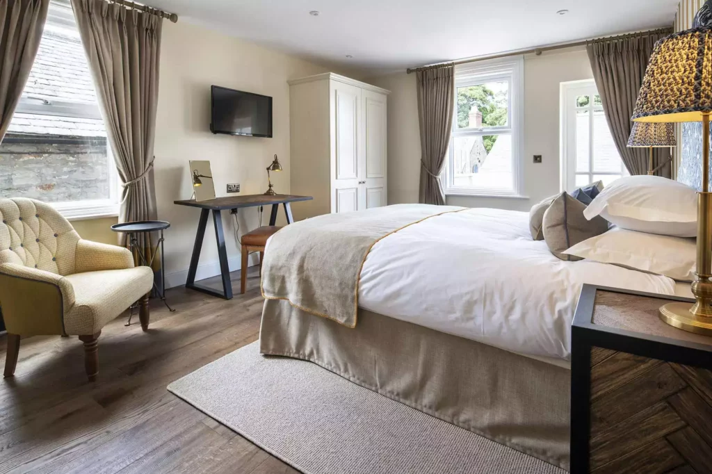 Bedroom with a cream chair and two open curtains