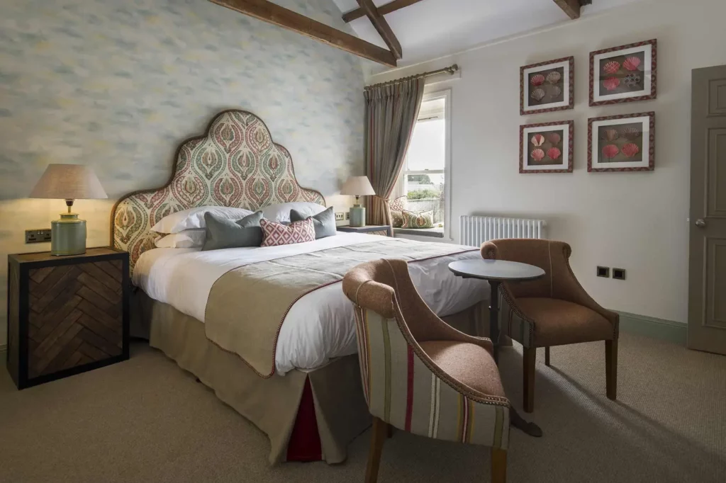 Bedroom with two chairs and four framed pictures