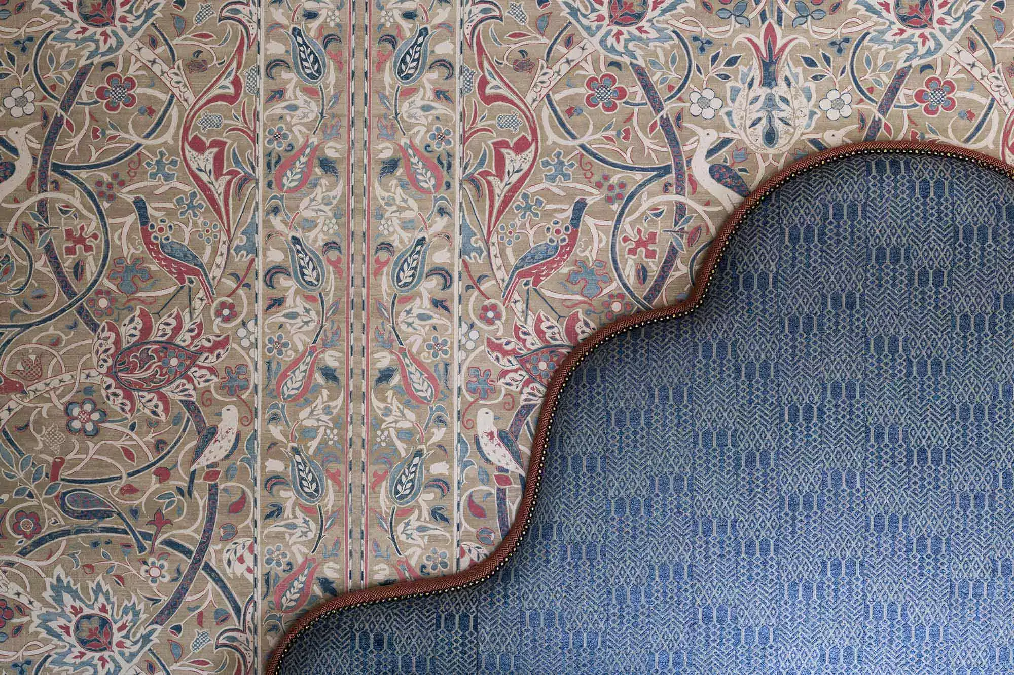 Top of a dark blue bed in front of the wallpaper