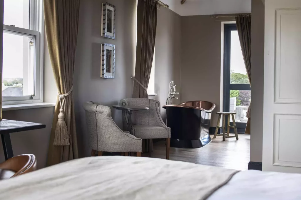 Bedroom with three chairs and a bathtub