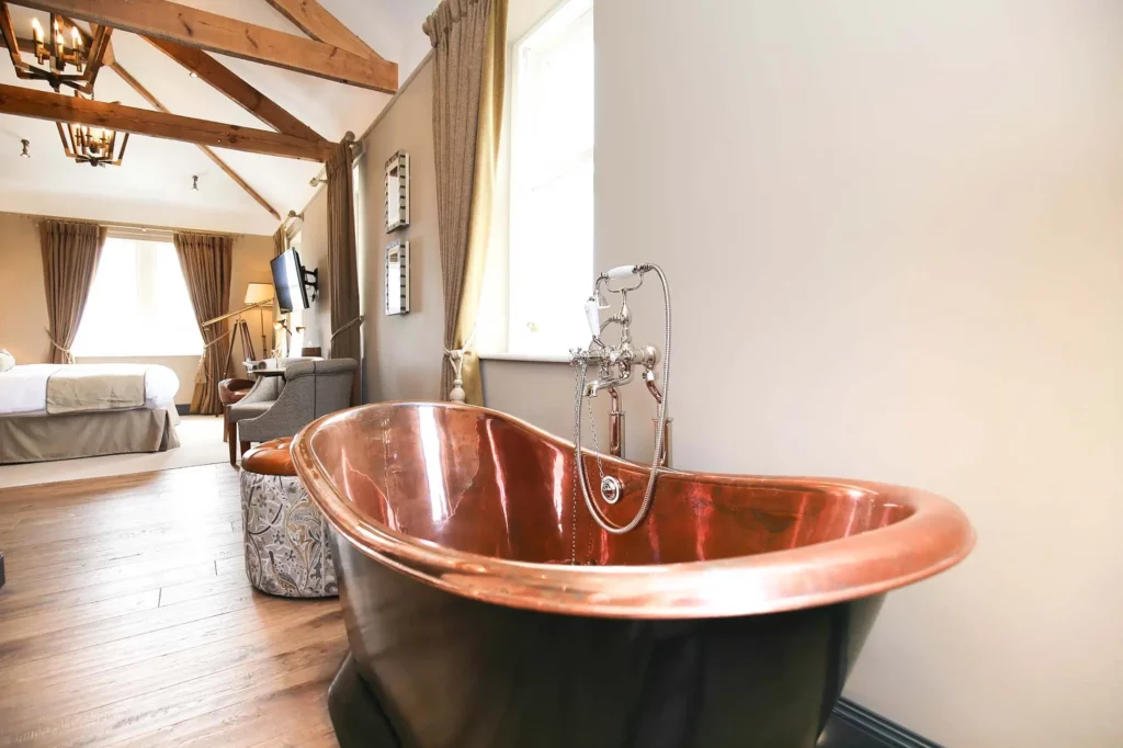 Bedroom with a black and copper bathtub